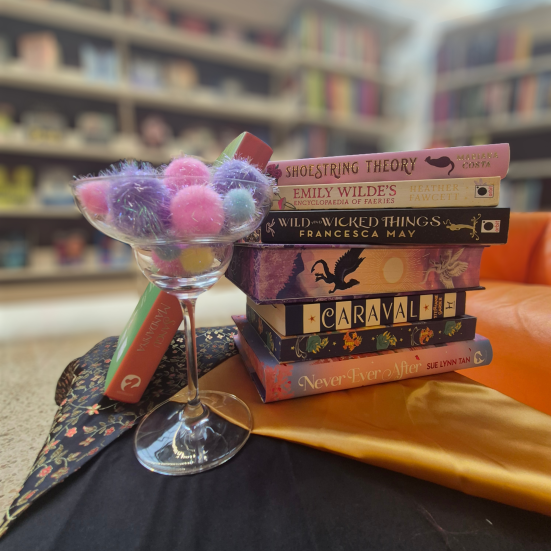 Foto af et lille tableau af romantasy-bøger og en mocktail på Faaborg Bibliotek.