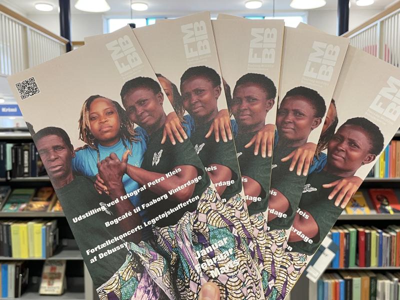 Billede af hånd der holder bibliotekets nye arrangementsfolder.